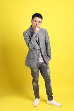 Sarı arka planda gri ceketli Asyalı LGBTQ adamı..