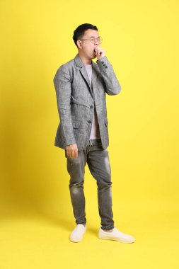 Sarı arka planda gri ceketli Asyalı LGBTQ adamı..