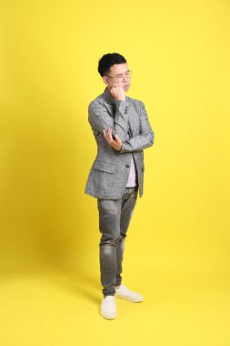 Sarı arka planda gri ceketli Asyalı LGBTQ adamı..