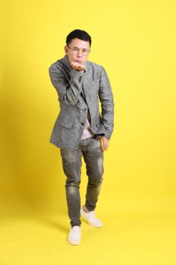 Sarı arka planda gri ceketli Asyalı LGBTQ adamı..