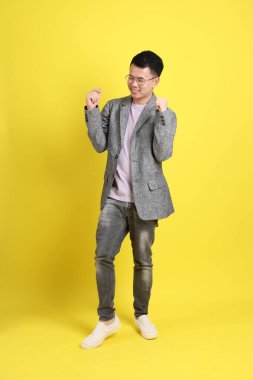 Sarı arka planda gri ceketli Asyalı LGBTQ adamı..