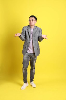 Sarı arka planda gri ceketli Asyalı LGBTQ adamı..