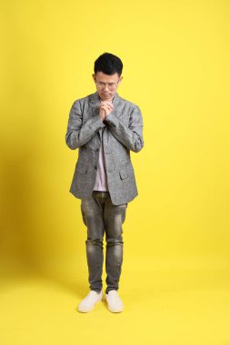 Sarı arka planda gri ceketli Asyalı LGBTQ adamı..