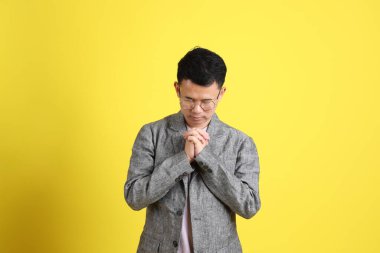 Sarı arka planda gri ceketli Asyalı LGBTQ adamı..