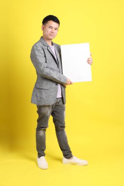 Sarı arka planda gri ceketli Asyalı LGBTQ adamı..