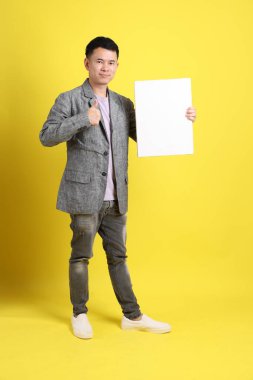 Sarı arka planda gri ceketli Asyalı LGBTQ adamı..