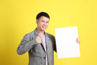 Sarı arka planda gri ceketli Asyalı LGBTQ adamı..