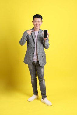 Sarı arka planda gri ceketli Asyalı LGBTQ adamı..