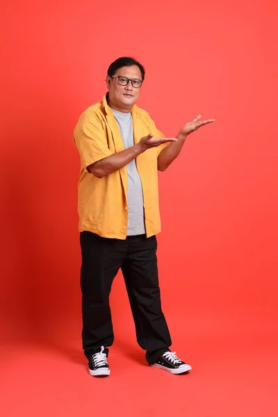 Adult Asian Man Yellow Shirt Standing Orange Background — Zdjęcie stockowe