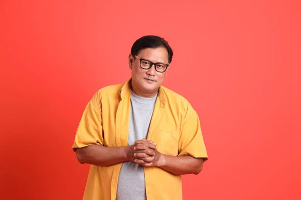 Turuncu Arka Planda Duran Sarı Gömlekli Yetişkin Asyalı Adam — Stok fotoğraf