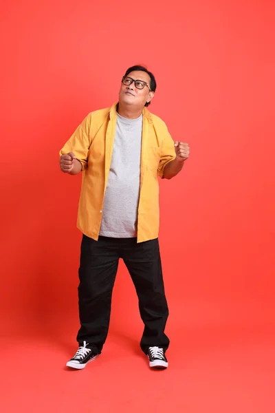 Der Erwachsene Asiatische Mann Mit Gelbem Hemd Steht Auf Orangefarbenem — Stockfoto