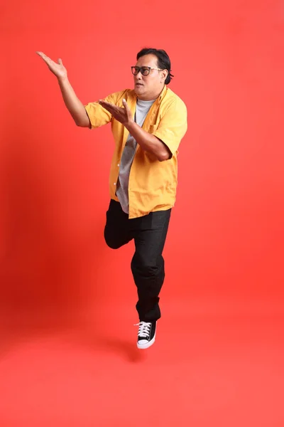 Adult Asian Man Yellow Shirt Standing Orange Background — Stockfoto