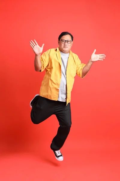 Adult Asian Man Yellow Shirt Standing Orange Background – stockfoto