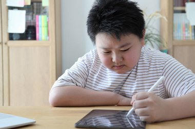 Asyalı çocuk tablete resim çiziyor.. 