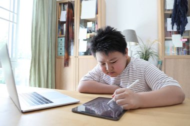 Asyalı çocuk tablete resim çiziyor.. 