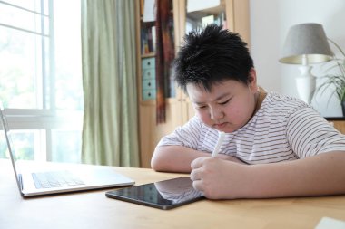 Asyalı çocuk tablete resim çiziyor.. 