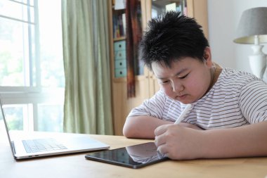 Asyalı çocuk tablete resim çiziyor.. 