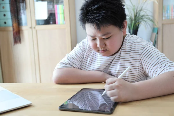 Asyalı çocuk tablete resim çiziyor.. 