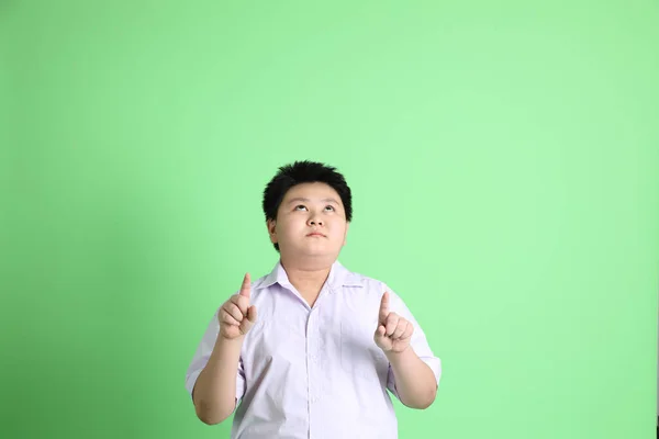 绿色背景上穿着学生服的亚洲男孩 — 图库照片