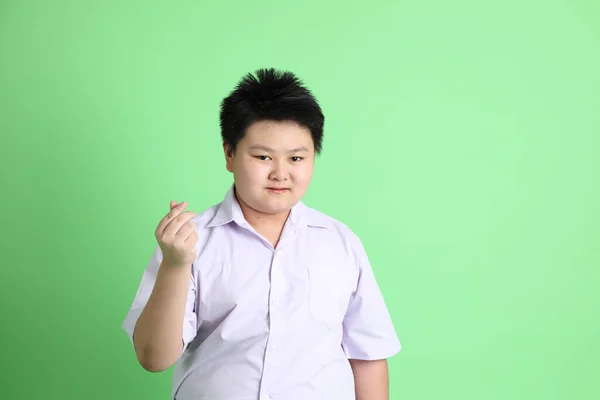 緑の背景に学生制服を着たアジアの少年 — ストック写真