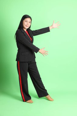 The Asian businesswoman standing on the pastel green background.