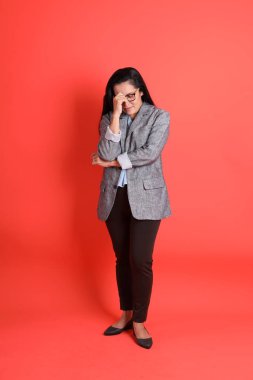 Turuncu arka planda duran Asyalı kıdemli iş kadını..