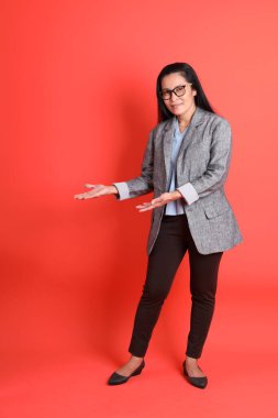 Turuncu arka planda duran Asyalı kıdemli iş kadını..