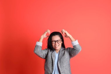 Turuncu arka planda duran Asyalı kıdemli iş kadını..