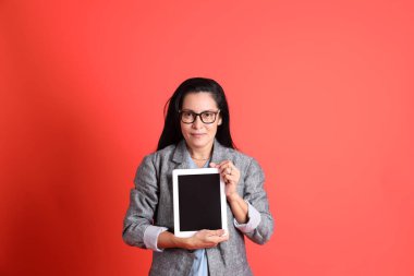 Turuncu arka planda duran Asyalı kıdemli iş kadını..