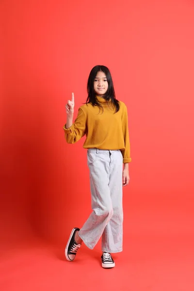 Turuncu Arka Planda Sarı Gömlekli Genç Asyalı Kız — Stok fotoğraf