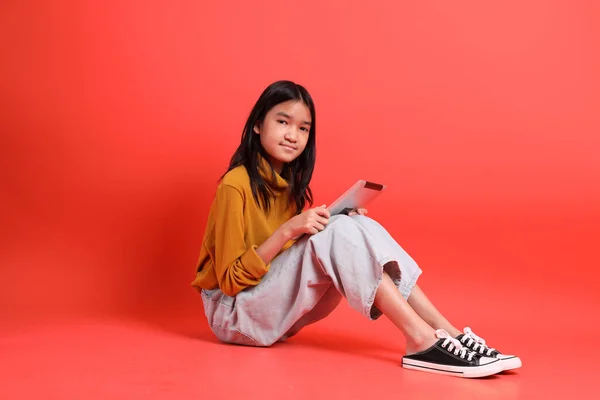 Gadis Asia Muda Dengan Kemeja Kuning Latar Belakang Oranye — Stok Foto
