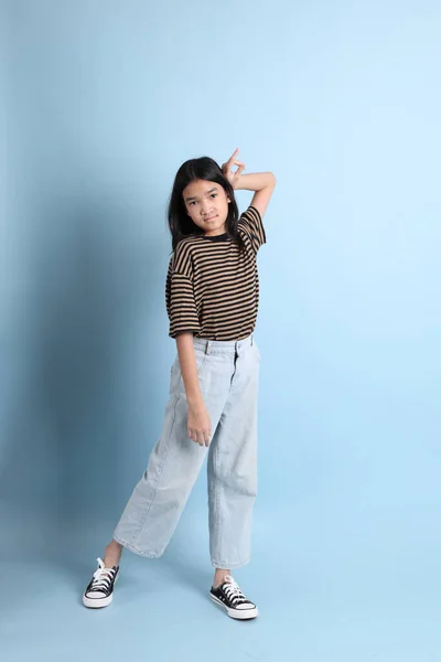 Mavi Arka Planda Kahverengi Gömlekli Genç Asyalı Kız — Stok fotoğraf