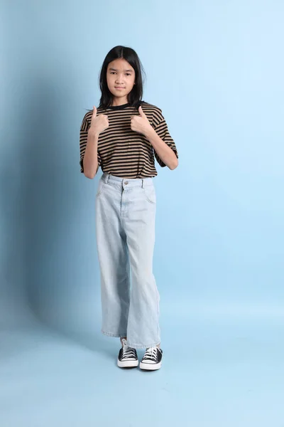 青の背景に茶色のシャツを着た若いアジアの女の子 — ストック写真
