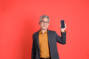 Asyalı kıdemli iş adamı orgazm arka planında duruyor..