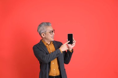 Asyalı kıdemli iş adamı orgazm arka planında duruyor..