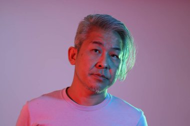 Neon ışıklı, güneş gözlüklü Asyalı adam.,