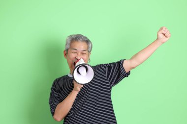 Yeşil arka planda sıradan tişörtlü 40 'lı yaşlardaki Asyalı adam..