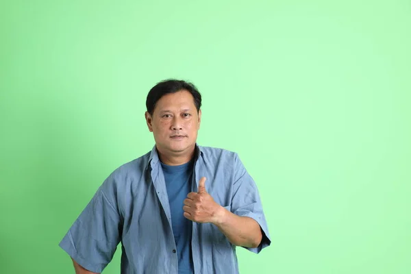 Yeşil Arka Planda Duran Yaşlardaki Aşırı Kilolu Asyalı Adam — Stok fotoğraf