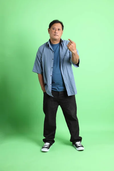 40代の大人太りすぎアジアの男は緑の背景に立って — ストック写真
