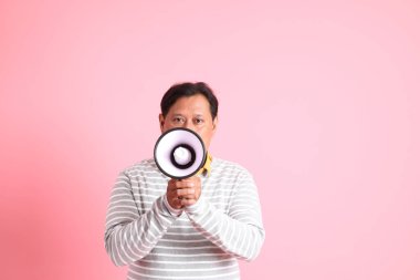 40 'lı yaşların aşırı kilolu Asyalı erkeği pembe arka planda duruyor..