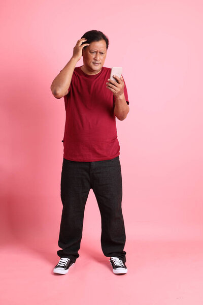 The 40s adult overweight Asian man standing on the pink background.