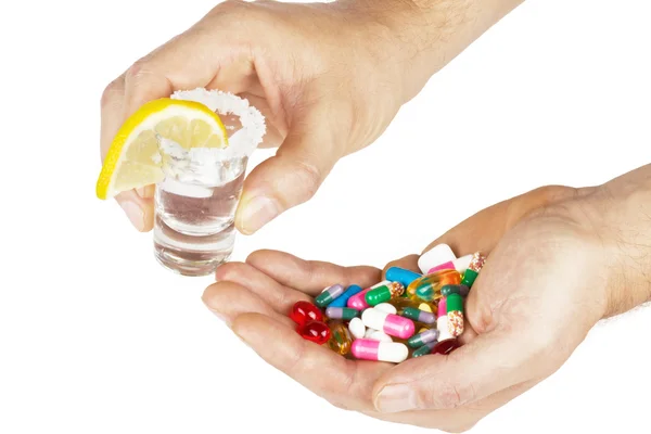 Alkohol und Medikamente in den Händen auf weiß — Stockfoto