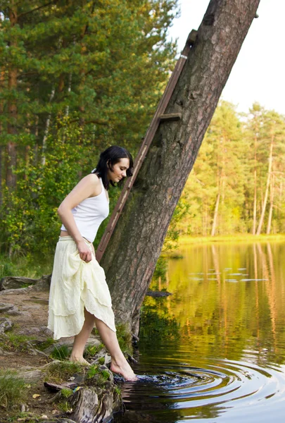 Woman touches water — Stock Photo, Image