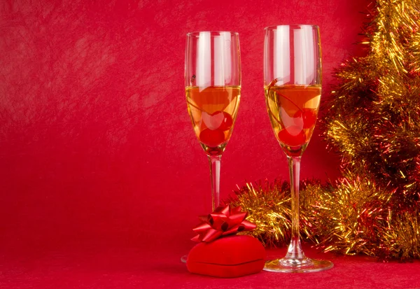 Christmas champagne glasses and present on red — Stock Photo, Image