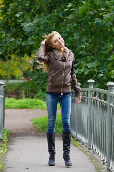 Jeune femme blonde marchant dans le parc — Photo