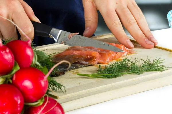 Woman cooking fish — Stock fotografie