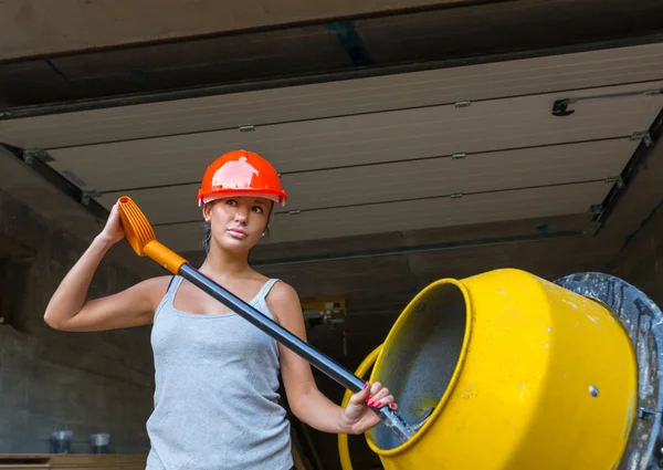 Ganska ung kvinna builder och betongblandare — Stockfoto