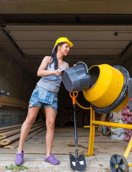 Ganska ung kvinna builder och betongblandare — Stockfoto