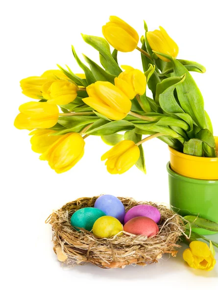 Пасхальные яйца в гнезде и цветы тюльпана — стоковое фото