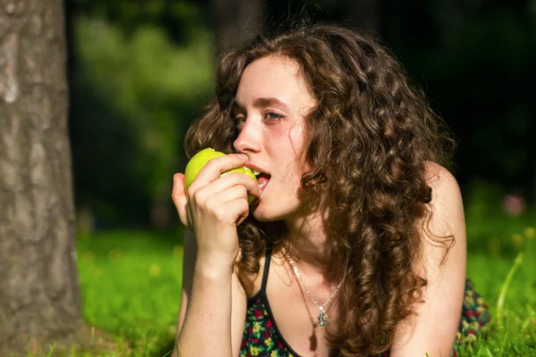 Beautiful young woman eating apple — Stock Photo, Image